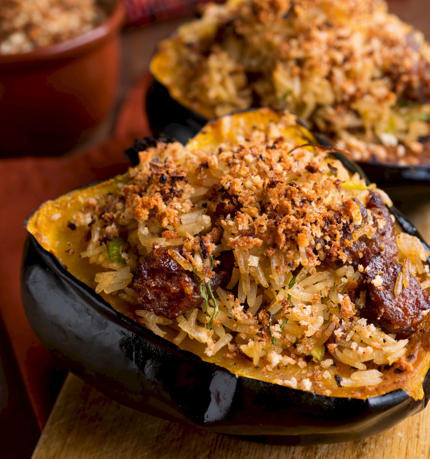 Loaded baked sweet potato halves with rice, herbs, and crunchy seasoning on a wooden board.