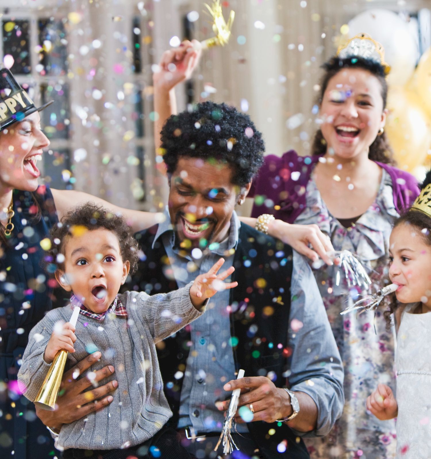 A lively birthday celebration with friends and kids cheering as confetti sparkles around them.